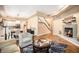Open concept living room with hardwood floors, cozy fireplace and staircase, seamlessly connected to the dining area and kitchen at 12051 E Lake Cir, Greenwood Village, CO 80111