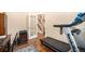 This home office has a treadmill and a view of the stairs and entry with white double doors at 12051 E Lake Cir, Greenwood Village, CO 80111