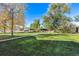 Lush backyard with mature trees, green grass and a walking path at 12901 2Nd St, Parker, CO 80134