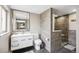 Bright bathroom featuring a modern vanity, toilet, and a walk-in shower with elegant gray tiling at 12901 2Nd St, Parker, CO 80134