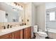 Bathroom with dual sinks, wooden cabinets, and a bathtub/shower combination, offering functionality and comfort at 12901 2Nd St, Parker, CO 80134