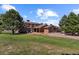 Brick house exterior with large yard and mature trees at 9696 E Sand Lily Ln, Parker, CO 80134
