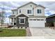 Beautiful two-story home featuring stone accents, a two-car garage, and manicured landscaping at 24798 E 40Th Ave, Aurora, CO 80019