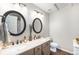 Bathroom featuring double sinks with stylish black framed mirrors and modern fixtures at 5252 W 68Th Ave, Arvada, CO 80003