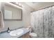 Bright bathroom features a shower with floral curtain, a framed mirror, and clean finishes at 5252 W 68Th Ave, Arvada, CO 80003