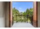 View from balcony featuring wrought iron railing and brick columns, overlooking green trees and a blue sky at 1631 N Emerson St # 207, Denver, CO 80218