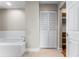 Bright bathroom with a soaking tub, closet, and view into the Primary bedroom at 1631 N Emerson St # 207, Denver, CO 80218