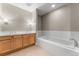 Bright bathroom with a soaking tub, double vanity, and tile floors at 1631 N Emerson St # 207, Denver, CO 80218