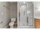 Bright bathroom with a glass-enclosed shower, toilet, and towel rack at 1631 N Emerson St # 207, Denver, CO 80218