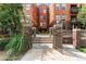 Exterior of a brick building with landscaped entrance, pathway, and wrought iron fence at 1631 N Emerson St # 207, Denver, CO 80218