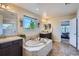 A bright bathroom with a soaking tub, double sinks, decorative plants and a window view at 7485 S Jackson Gap Way, Aurora, CO 80016