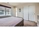 A sunlit bedroom showcasing a bed, window and view with an open closet for storage at 7485 S Jackson Gap Way, Aurora, CO 80016