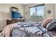 Comfortable bedroom with soft blankets, dresser, and large window for natural light at 7485 S Jackson Gap Way, Aurora, CO 80016