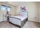 A cozy bedroom featuring a gray bed frame and an Eiffel tower decoration near a large window at 7485 S Jackson Gap Way, Aurora, CO 80016