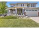 Charming two-story home featuring a welcoming front porch, lush green lawn, and attached two-car garage at 7485 S Jackson Gap Way, Aurora, CO 80016