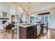 Open-concept kitchen with granite counters, stainless appliances, island with seating, and hardwood floors at 7485 S Jackson Gap Way, Aurora, CO 80016