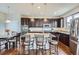 Modern kitchen featuring dark cabinets, granite countertops, stainless steel appliances, and bar seating at 7485 S Jackson Gap Way, Aurora, CO 80016