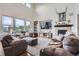 Bright and airy living room featuring a cozy fireplace, large windows, and comfortable seating at 7485 S Jackson Gap Way, Aurora, CO 80016