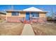 Charming single-story home with a brick facade, a blue front door, and a well-maintained walkway at 8520 Franklin Dr, Denver, CO 80229