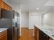 Open kitchen with stainless fridge, granite counters, and ample storage at 6000 W Floyd Ave # 105, Denver, CO 80227
