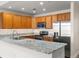 Bright kitchen with stainless appliances, oak cabinets, and granite countertops at 6000 W Floyd Ave # 105, Denver, CO 80227