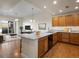Open kitchen featuring a large island with a granite countertop and stainless steel appliances and warm wood cabinetry at 6000 W Floyd Ave # 105, Denver, CO 80227