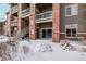 Brick building exterior with snow-covered landscaping and a covered entryway at 804 Summer Hawk Dr # 9103, Longmont, CO 80504