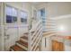 Bright entryway with wood stairs and railing leading to a door, complemented by natural light from nearby windows at 1560 Clinton St, Aurora, CO 80010