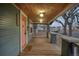 Covered front porch featuring wood ceiling and a charming pink front door at 1560 Clinton St, Aurora, CO 80010