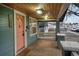 Covered front porch with wood ceiling and a charming pink front door at 1560 Clinton St, Aurora, CO 80010