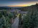 Beautiful aerial view of estate home nestled within the trees with mountain views at sunset at 28154 Belle Mont Trl, Conifer, CO 80433