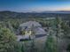 Scenic aerial view of a gorgeous home surrounded by mature trees with mountain range backdrop at 28154 Belle Mont Trl, Conifer, CO 80433