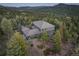 Aerial view of a large home nestled amongst lush forest with mountain views at 28154 Belle Mont Trl, Conifer, CO 80433