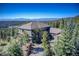 Beautiful aerial shot of a home nestled amongst trees with blue sky and mountain views at 28154 Belle Mont Trl, Conifer, CO 80433