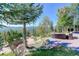 Stunning outdoor space with stone patio and beautiful green area with outdoor seating at 28154 Belle Mont Trl, Conifer, CO 80433
