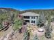 A large estate with a backyard featuring a hot tub and a large stone patio and seating at 28154 Belle Mont Trl, Conifer, CO 80433