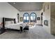 Bright primary bedroom with a fireplace, sitting area, and views from arched windows at 28154 Belle Mont Trl, Conifer, CO 80433