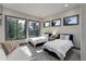 Bright bedroom featuring two twin beds, large windows, and a cozy seating area at 28154 Belle Mont Trl, Conifer, CO 80433