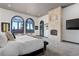 Primary bedroom boasts a fireplace, arched windows with views, and stylish decor at 28154 Belle Mont Trl, Conifer, CO 80433