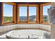 Soaking tub overlooking the mountain views, surrounded by tile and wood trimmed windows at 278 Snowshoe Cir, Breckenridge, CO 80424