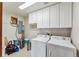 Functional laundry room with white cabinets, a washer, a dryer, and ample storage space at 278 Snowshoe Cir, Breckenridge, CO 80424