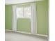 Bright bedroom with green walls, white trim, and a window with flowing white curtains at 4821 W 102Nd Ave, Westminster, CO 80031