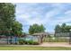 Beautiful community pool surrounded by lush trees with lounge chairs and a glimpse of the mountains in the background at 4821 W 102Nd Ave, Westminster, CO 80031