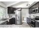 Modern kitchen with dark cabinets, granite countertops, stainless steel appliances, and a bright window over the sink at 4821 W 102Nd Ave, Westminster, CO 80031
