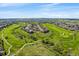 An aerial view showcases homes built into a golf course with green grass and surrounding open spaces at 23298 Barnsley Ln, Parker, CO 80138