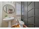 Modern half bathroom featuring a pedestal sink, toilet, and decorative wall paneling at 23298 Barnsley Ln, Parker, CO 80138