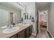 Well-appointed bathroom boasts double sinks, wood-look flooring, and a convenient doorway to an adjacent bedroom at 23298 Barnsley Ln, Parker, CO 80138