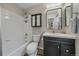 Well-lit bathroom with a shower-tub combo, updated fixtures, and a dark wood vanity offering ample storage at 23298 Barnsley Ln, Parker, CO 80138