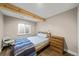 Bedroom with exposed wood beam, window and wood dresser at 2757 Stallion Way, Mead, CO 80542