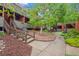 Inviting walkway to building entrance with landscaped yard and mature trees on a bright day at 3050 W 32Nd Ave # 104C, Denver, CO 80211